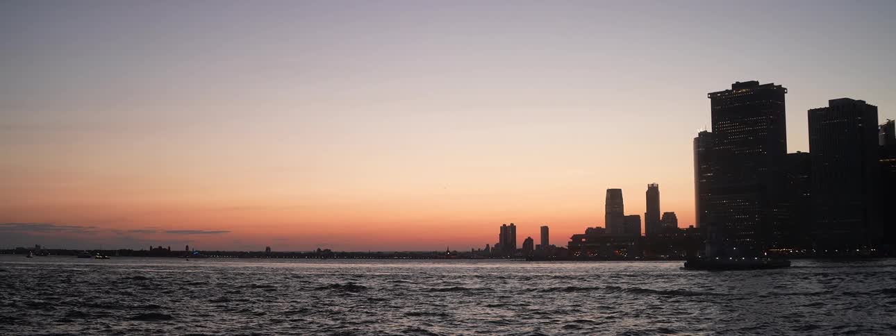 Tall buildings and skyscrapers on the metropolitan coast as boats sail on the water