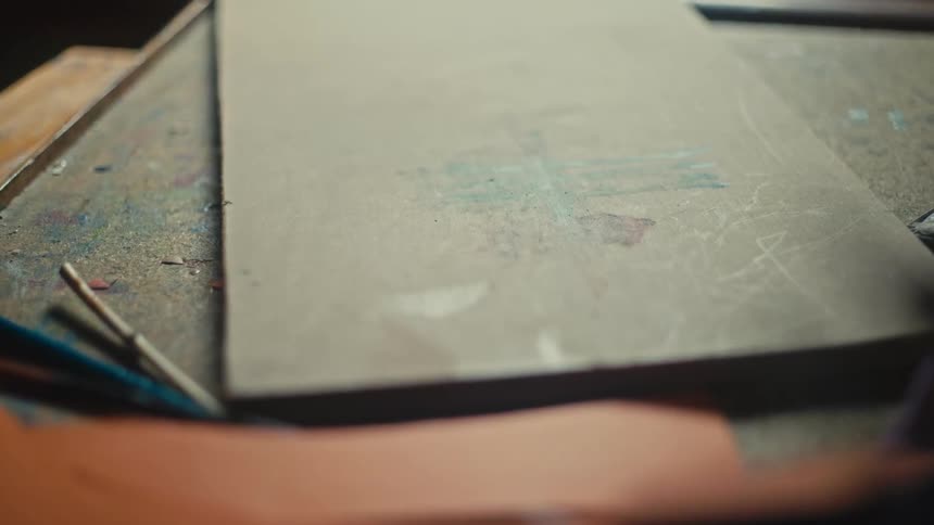 A board on a desk covered in spilled paint