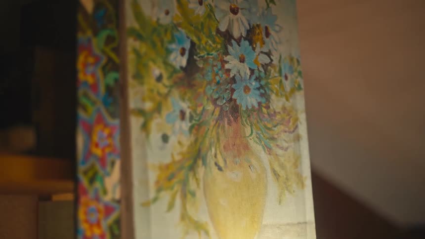 A impressionistic painting of white and light blue daisies held in a yellow vase which is mounted on the side of a column