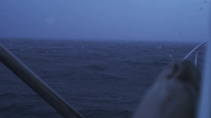 A boat is floating on the waves far out at sea