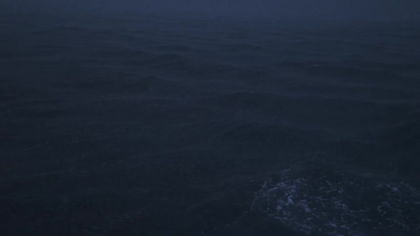 The dark ocean surface ripples faintly in the dim fogshrouded light