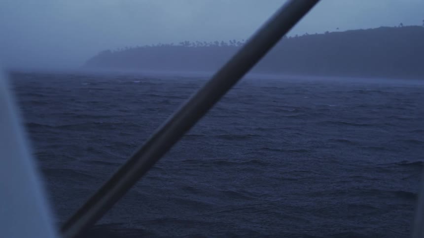 Foggy coastline appears in the distance over the dark blue sea