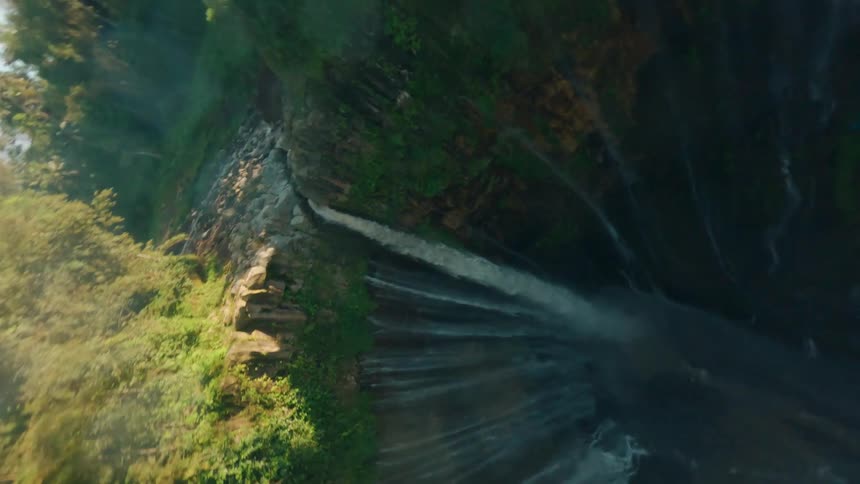 Tall waterfall surrounded by dense tropical vegetation