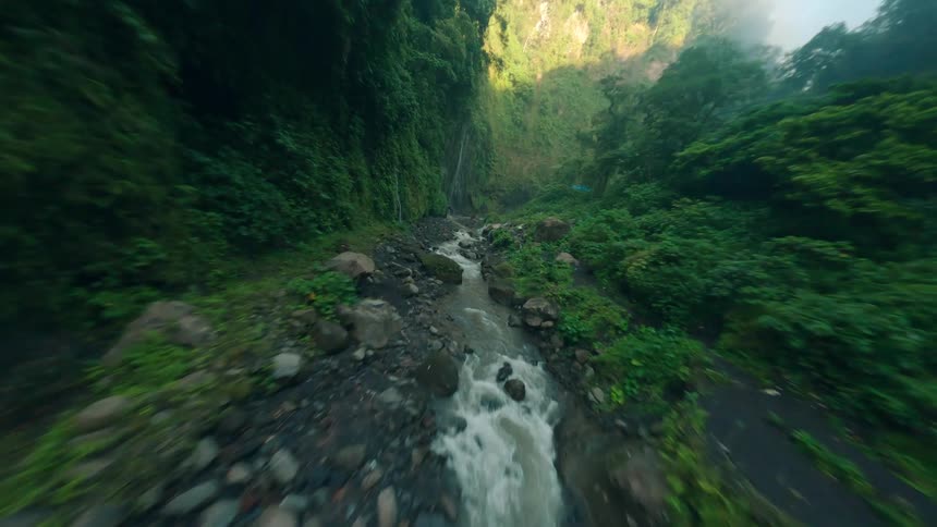 Waterfalls cascade through a valley covered in dense moist vegetation