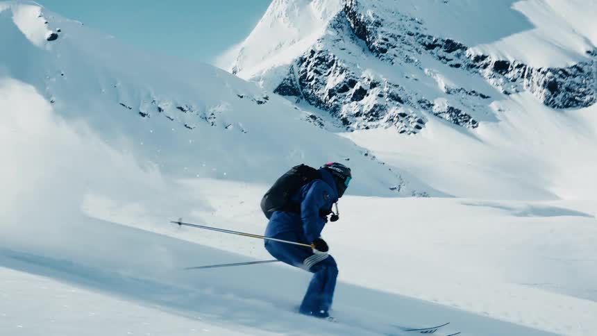 Skier makes a sharp turn on a slope covered with soft snow