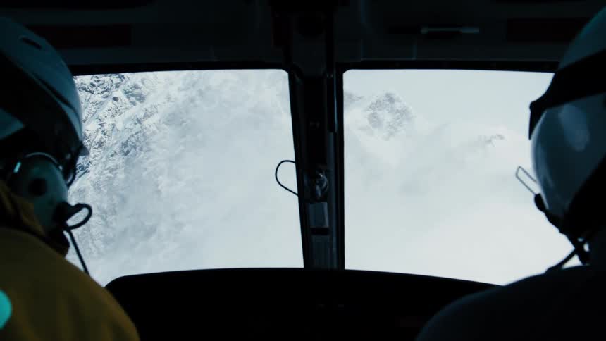 Pilots observe snowcovered mountains through the cockpit window