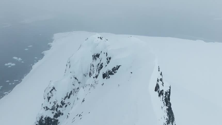 Aerial view of snow covered mountains along the arctic coast