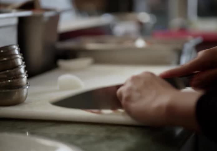 A view of a person chopping food in a kitchen