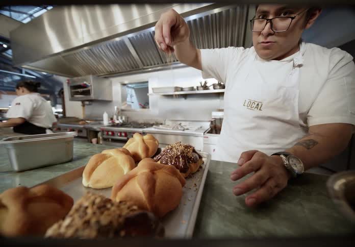 Baker finishing sweet breads with topping and sprinkles