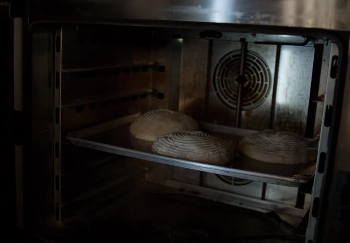 A man putting food into an oven at a restaurant
