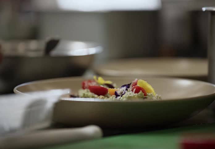 A chef is putting the final garnishes on a plate of food
