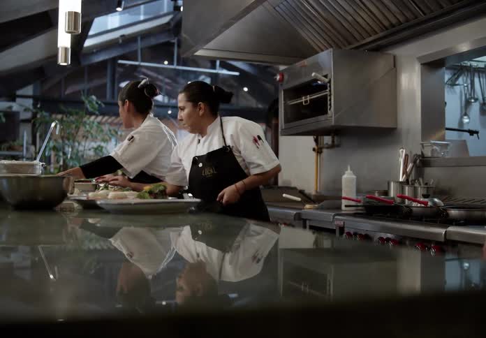 The cooks are working in the restaurants kitchen