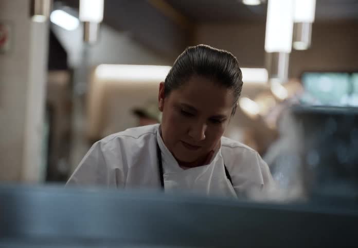 Cook focused on preparing a dish in the professional kitchen