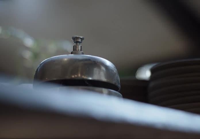 A customer uses their hand to hit the top of a service bell