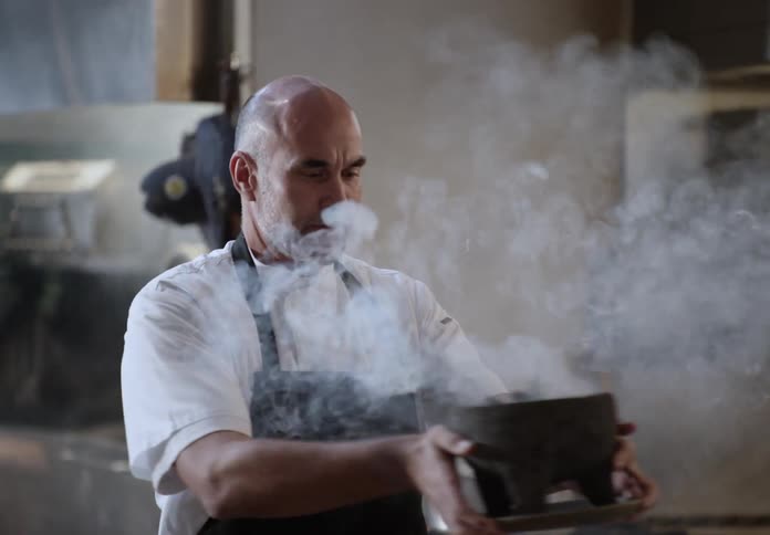 The chef spreads incense through the restaurant kitchen