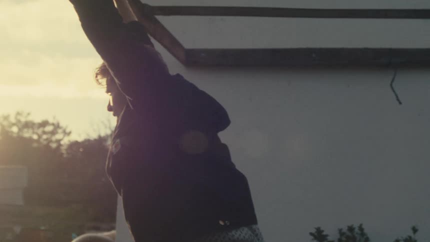 A man looks upset as he holds his arms up and looks into his yard