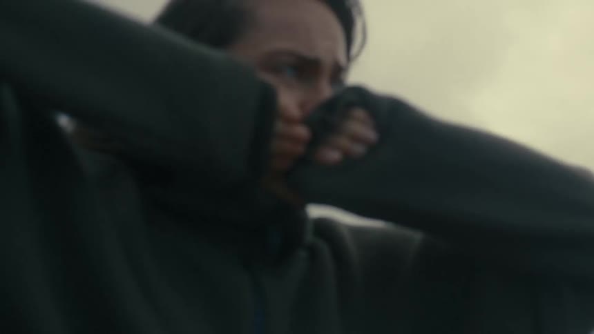 Woman covering her face with her sleeves in a moment of distress