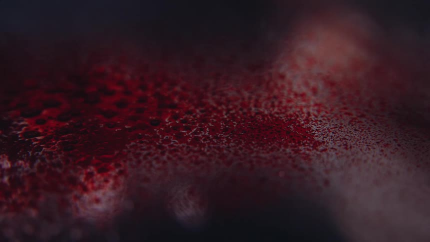 Dark red powder is sprinkled and scattering on a silver blurred surface
