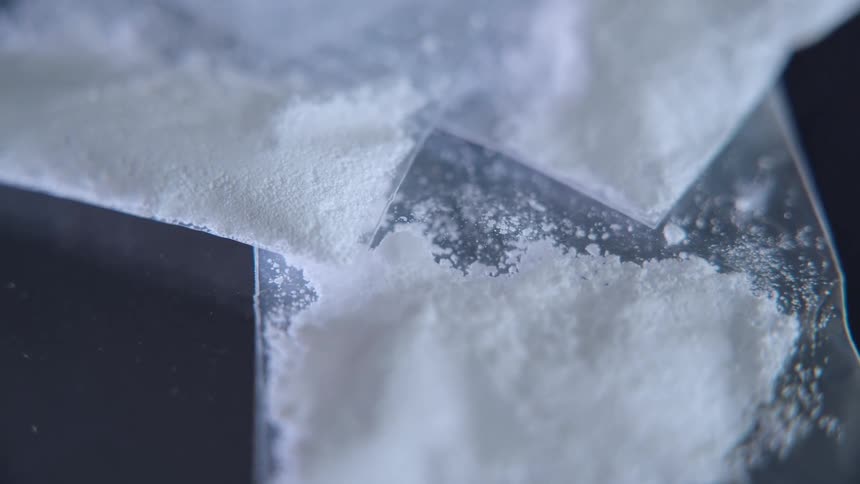 Plastic bags holding a white powdery substance lie on a gray surface
