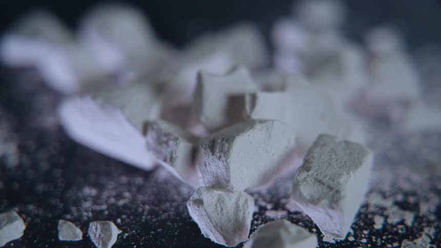 White brittle fragments scattered across a dark surface