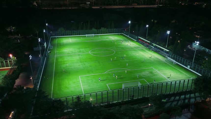 Night soccer match on a field lit by floodlights
