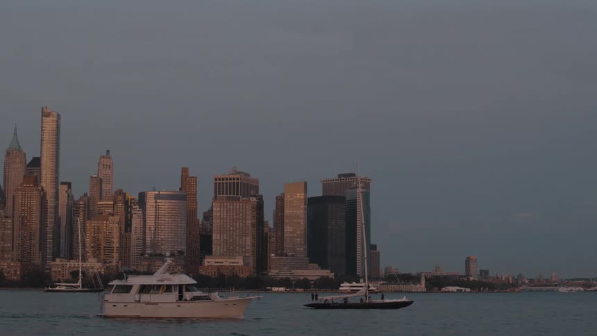 Boats move past the big city during the day