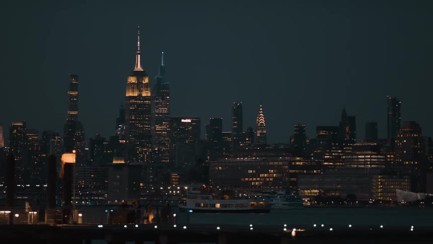 The buildings in a city are lit up at night