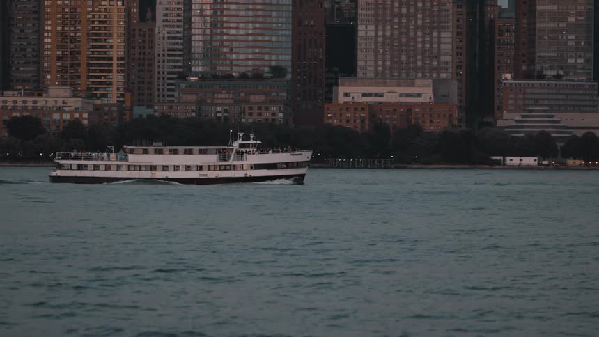 A boat sailing next to a large city