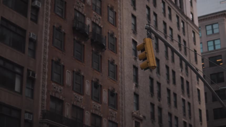 Yellow traffic light contrasts with the old building faades