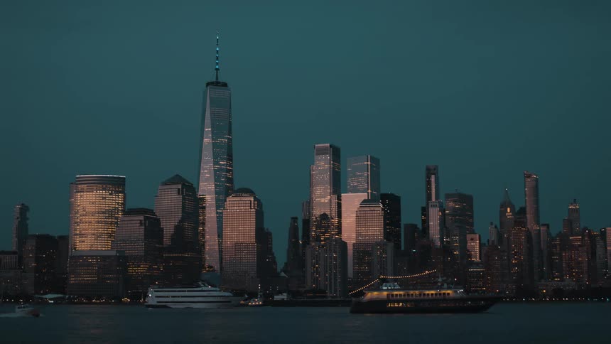 City skyline reflects golden lights over the river at dusk