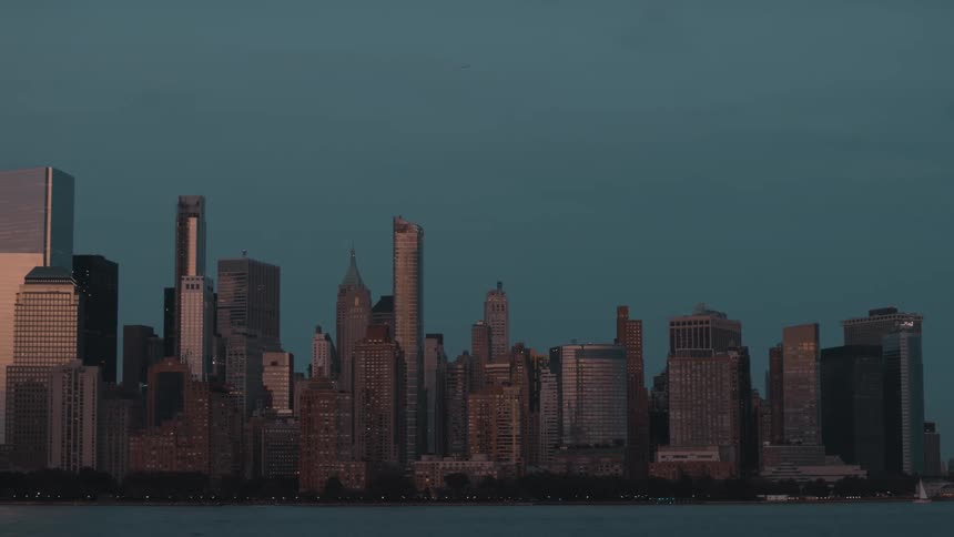 City skyline lit by the sunset reflects golden tones on the skyscrapers