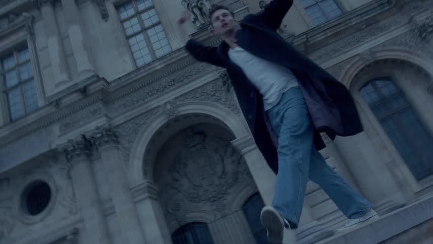 Two people dance in front of a historic building with classical architecture