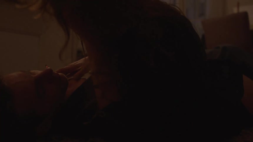 Couple lies on the floor in a candlelit room sharing an intimate moment