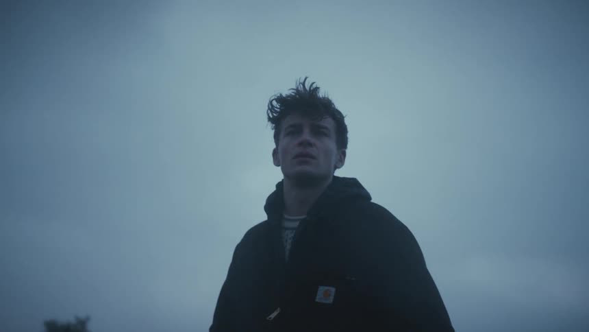 Man stares at the horizon under the cold evening light