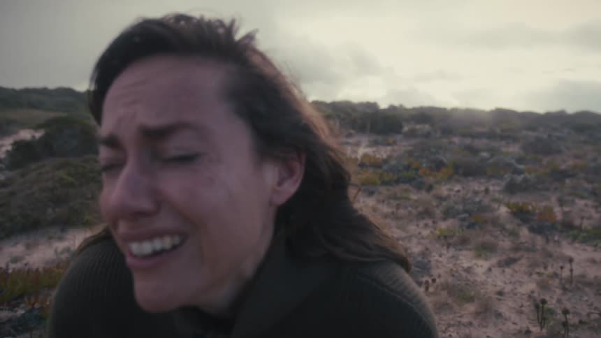 Woman cries outdoors overcome by emotion in the field