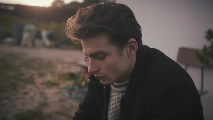 Man looks down in silence lost in thought outdoors