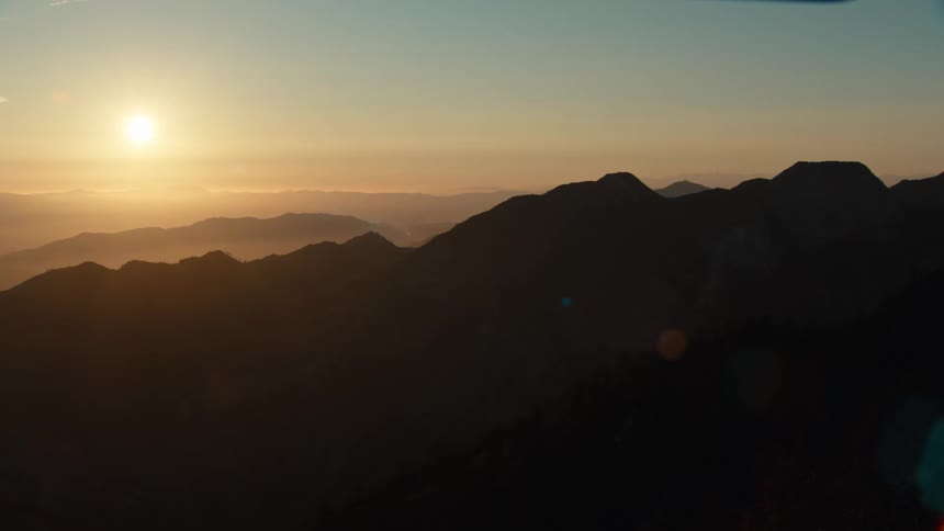 A view of the sun in the distance over mountains