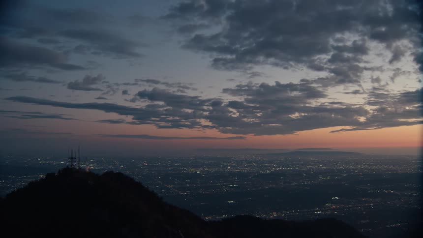 Dusk falls over a community as seen from atop a mountain