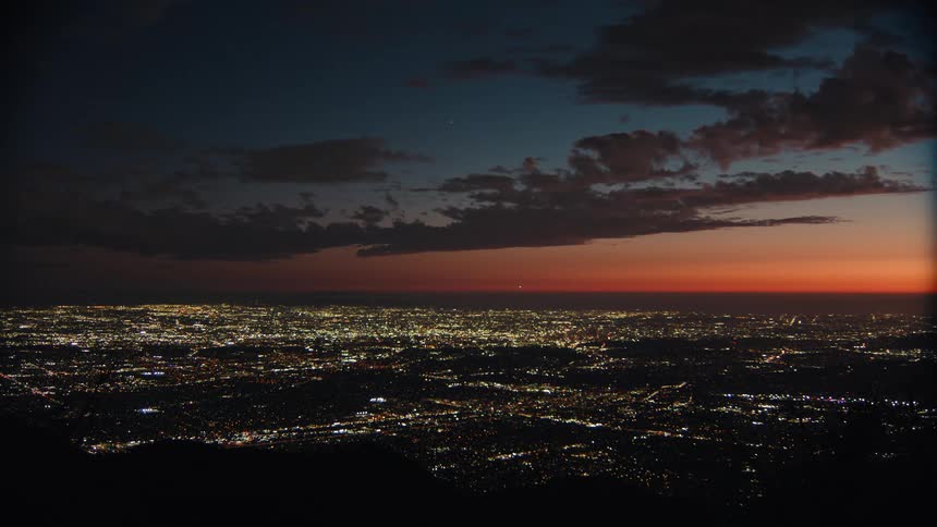 City lights stretch beneath the orange sunset