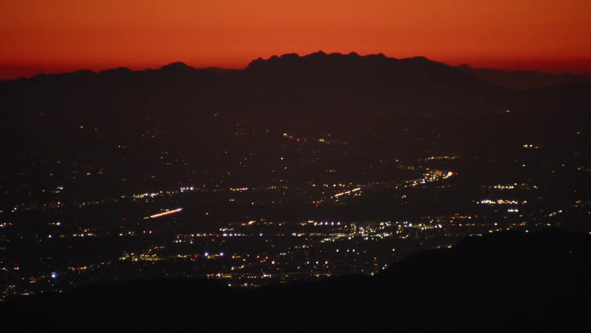City skyline glowing at dusk under an orange sky