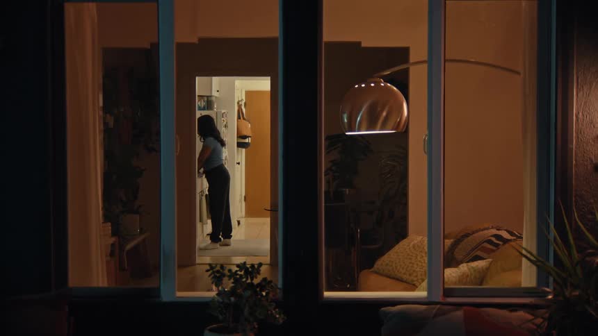 Man smoking enters the house and goes to join a woman in the kitchen