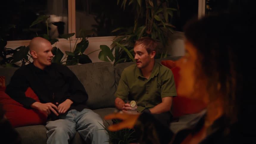 Friends talk and have drinks together at home