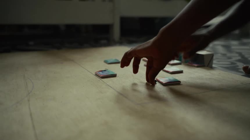 Child plays on the floor with small pieces during the daytime