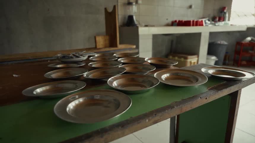 A green table with several empty metal plates on it