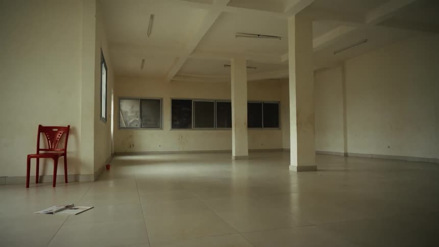 Spacious empty room with a red chair leaning against the wall