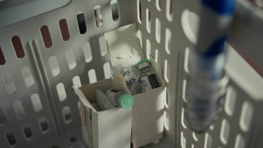 Box with vials and syringes stored inside a plastic basket