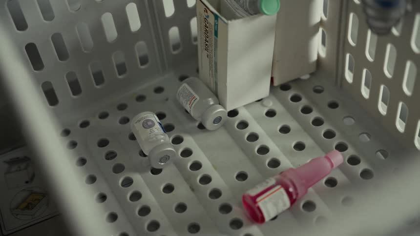 Glass vials of medications are in a plastic basket