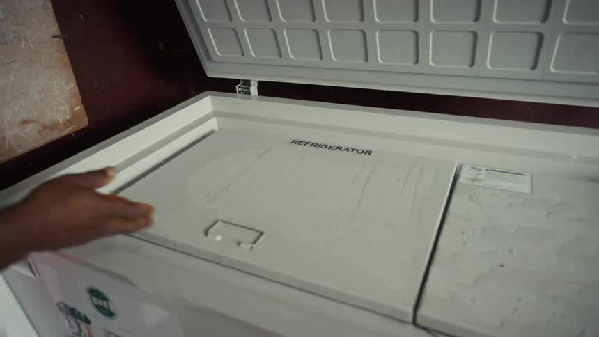 A persons hands lift the lids off a freezer to show the inside compartments