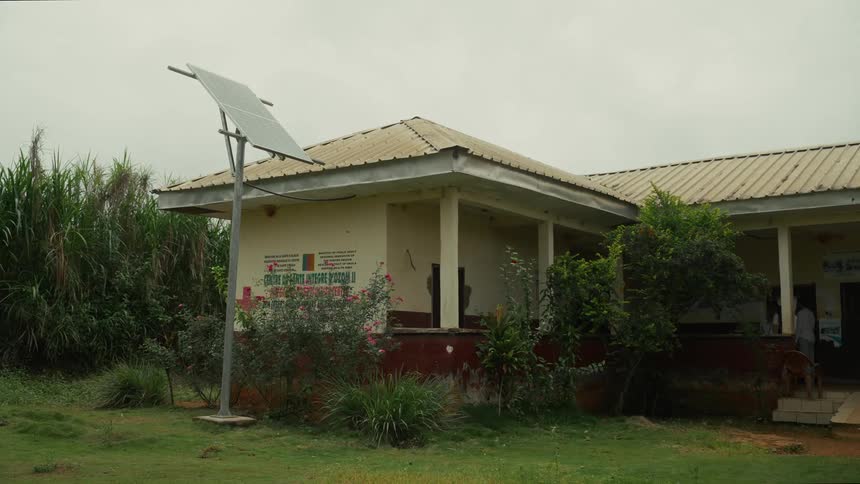 Solar panel on a pole outside of a building and people on the porch