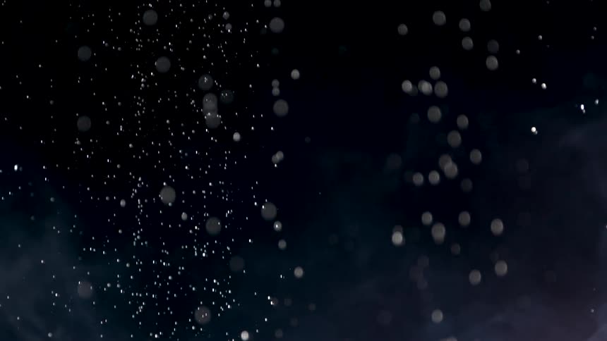 It features a dark background with numerous small bright particles resembling dust bokeh or snow falling and floatingthe text filmsupply appears in the center of the frame visible throughout the clip